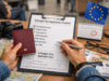 How To Apply For A Schengen Visa Traveler reviewing Schengen visa application documents with passport and checklist before embassy appointment