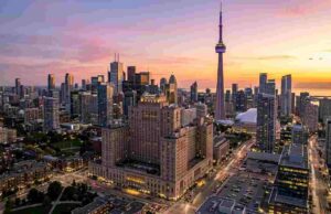 The Ultimate Guide to the Best Hotels in Toronto for Tourists (2026 Edition) Panoramic view of Toronto skyline at sunset featuring the CN Tower and luxury downtown hotels.