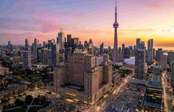 The Ultimate Guide to the Best Hotels in Toronto for Tourists (2026 Edition) Panoramic view of Toronto skyline at sunset featuring the CN Tower and luxury downtown hotels.