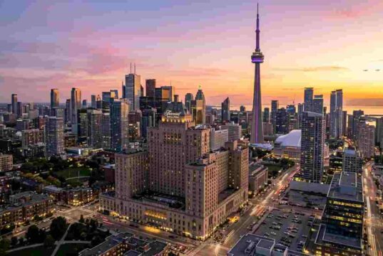 The Ultimate Guide to the Best Hotels in Toronto for Tourists (2026 Edition) Panoramic view of Toronto skyline at sunset featuring the CN Tower and luxury downtown hotels.